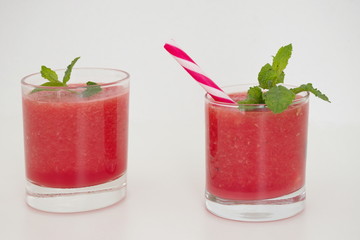 Smoothie of watermelon with mint leaves against the white background