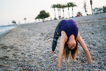 Young healthy Yoga woman practicing yoga pose on the beach at sunrise, benefits of natural environments for physical, spiritual, healthy, relaxing concept.