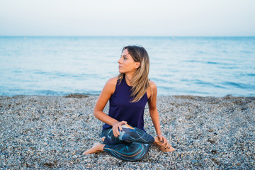 Young healthy Yoga woman practicing yoga pose on the beach at sunrise, benefits of natural environments for physical, spiritual, healthy, relaxing concept.