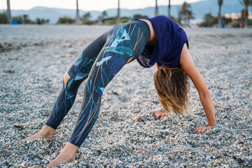 Young healthy Yoga woman practicing yoga pose on the beach at sunrise, benefits of natural environments for physical, spiritual, healthy, relaxing concept.