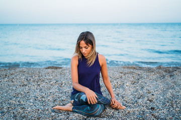 Young healthy Yoga woman practicing yoga pose on the beach at sunrise, benefits of natural environments for physical, spiritual, healthy, relaxing concept.