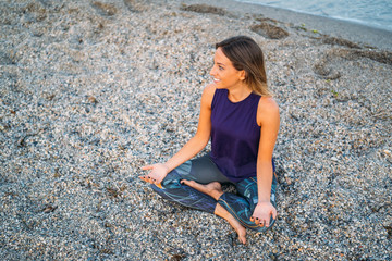 Young healthy Yoga woman practicing yoga pose on the beach at sunrise, benefits of natural environments for physical, spiritual, healthy, relaxing concept.