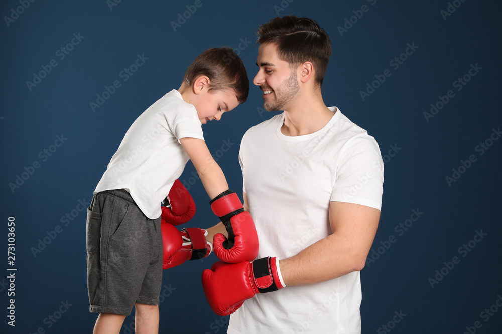 Sticker Dad and his son with boxing gloves on color background