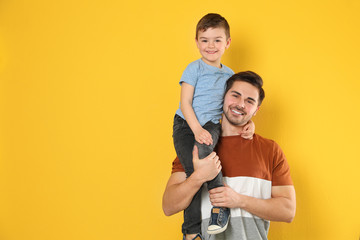 Portrait of dad and his son on color background. Space for text