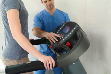 Fototapeta na wymiar Patient exercising under physiotherapist supervision in rehabilitation center