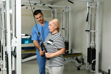 Patient exercising under physiotherapist supervision in rehabilitation center