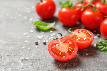 Cherry tomatoes with spice and basil on stone background. Space for text