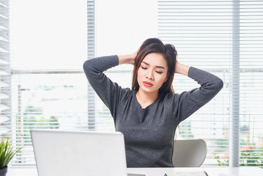 Young Bored Woman Feeling Drowsy At Office Sitting With Laptop Computer.