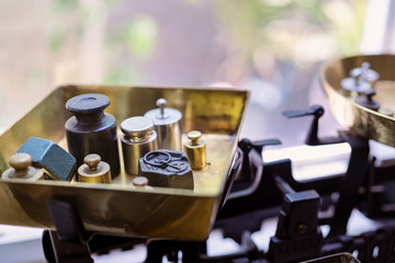 Old fashioned weights or rusty weights are on balance scale. Many kind of colorful weights used in the past. Isolated weights in vintage style with bright on background. Royalty high quality image.