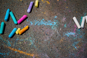 Colorful children's crayons on asphalt, background, close up