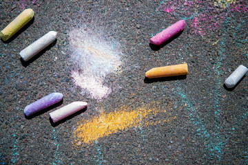 Colorful children's crayons on asphalt, background, close up