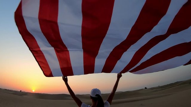 US flag - woman athlete showing american flag. Beautiful cheering happy young multicultural girl joyful excited.