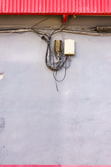 Cable power cords in tangled mess on wall outdoor
