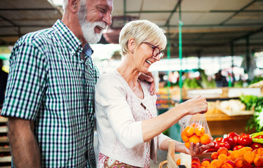 Fototapeta na wymiar Picture of senior couple at marketplace buying vegetables