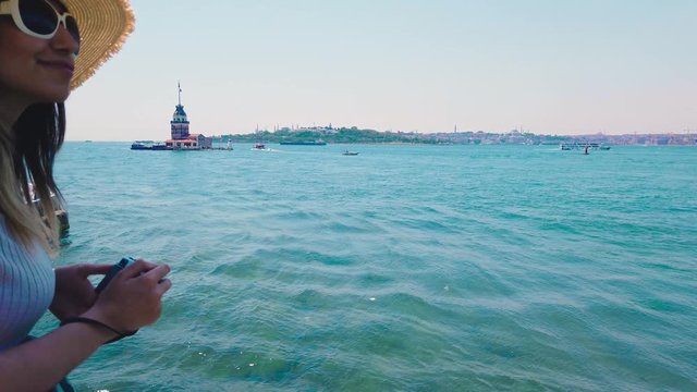 Slow motion:Beautiful girl takes pictures of Bosphorus  and  Maidens Tower in Uskudar town,Istanbul,Turkey