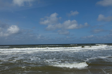 Fototapeta na wymiar Dutch coast. Beach and dunes at Northsea Netherlands. Clouds.