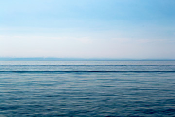 Lake Baikal on a sunny day. Clear blue sky and water. Free space for text. Background for design, screen saver