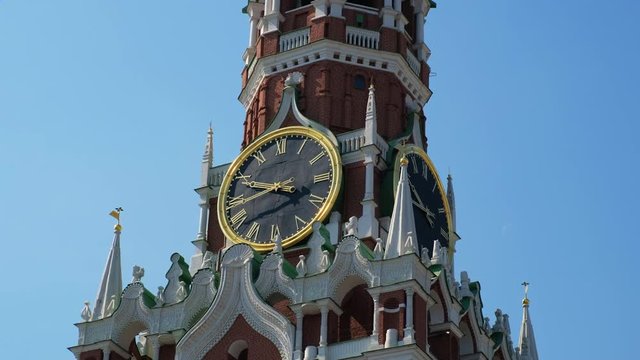 Close-up clock on Spasskaya Tower of the Kremlin against the blue sky on a sunny summer day. Sight of Moscow, the capital of Russia. Red Square, City center, tourist  place