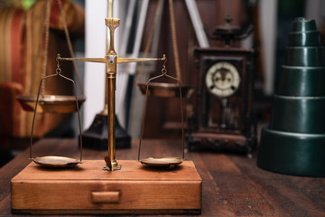 Obraz na płótnie Canvas Many kind of old fashioned balance scales on wooden table. Colorful ancient balance scales in vintage background, isolated. the symbol of Lawyer. Royalty high quality free stock image.