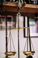 Many kind of old fashioned balance scales on wooden table. Colorful ancient balance scales in...