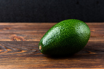 Avocado on dark wooden background.