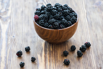 Fototapeta na wymiar Sweet blackberry in wooden bowl on wooden table