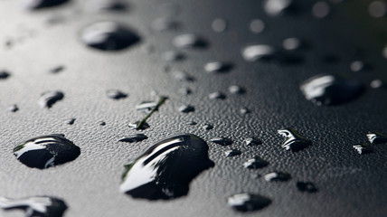 Waterdrops on black leather. Rain. Moist.
