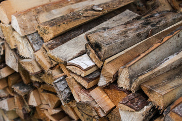 Beautiful countryside view of timber firewood stacked in a big stack near home in a countryside village home. 