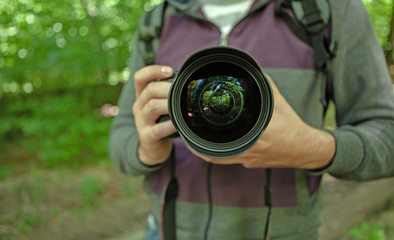 Fototapeta premium A photographer takes a summer forest on camera