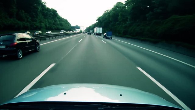 A highly stylized clip of a car speeding down the highway on the German autobahn. Highway dashcam deep blue grade.