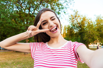 Fototapeta premium Beautiful urban woman taking picture of herself, selfie