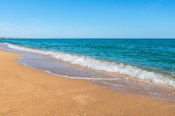 Fototapeta na wymiar Empty summer beach with golden sand and azure water