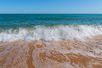 Empty summer beach with golden sand and azure water