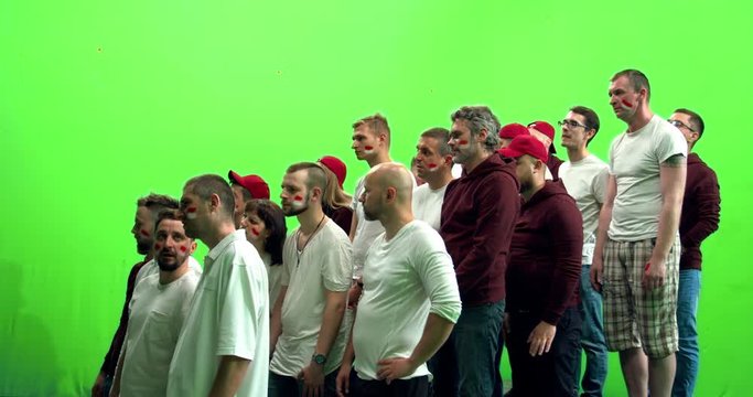 GREEN SCREEN CHROMA KEY 3/4 view group of people fans wearing red clothes watching a sport event. 4K UHD ProRes 422 HQ