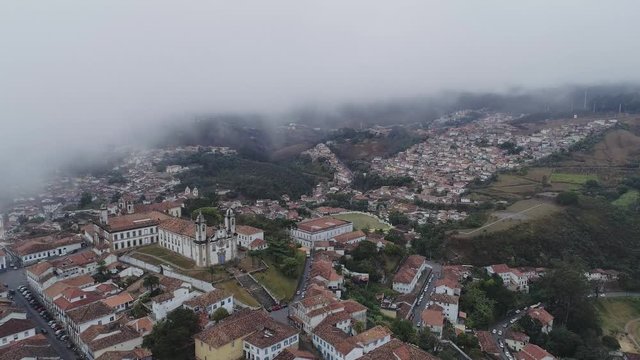 Drone image of an historical city going up into the clouds, minas gerais, Brazil.