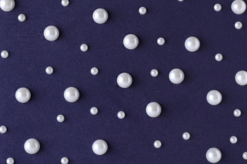 Dark blue background with pattern from pearls bead. Flat lay. Minimal.