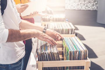 Man browsing vinyl album on sale. Beautiful male hands in the frame.