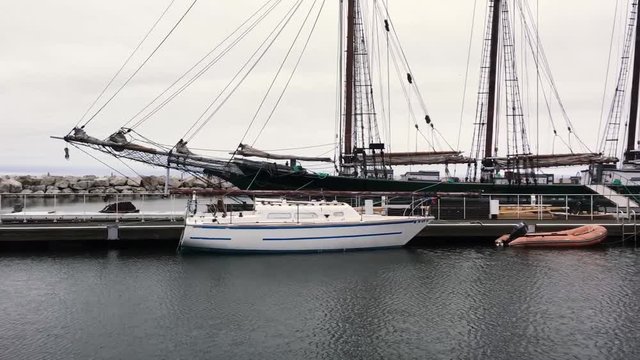Pan Right of Beautiful Sail Boat Docked Next to Discovery World Building Milwaukee
