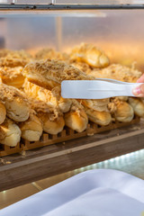 Closeup of human hand picking bread with pork floss topping