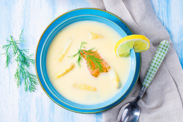 Cream of asparagus soup with salmon rolls and dill