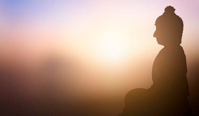 Buddhist concept: Buddha statue on the background of the sunset