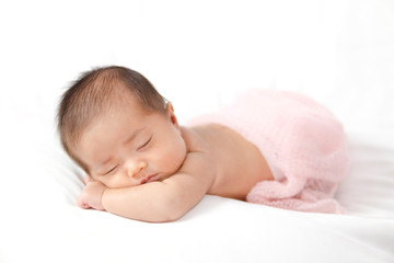 Adorable asian newborn baby in pink wrap sleeping on white blanket background.