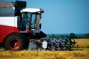 Obraz premium Machines harvesting wheat in the field in autumn.