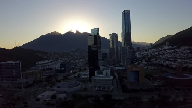 Aerial drone shot of the sunrise in the Cerro de la Silla with the San Pedro Skyline. Nuevo Leon