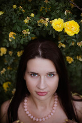 Naklejka premium portrait of a young girl in yellow rosehips