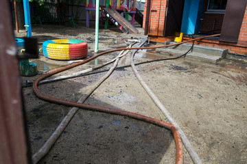 Smoldering remains of a ghetto house with a fireman spraying water