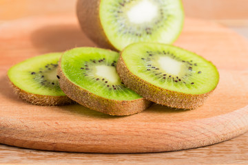 close up of wooden cutting board with sliced kiwi
