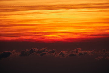 Sunrise / sunset over the clouds and horizon in golden colors.