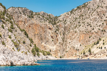 Fototapeta na wymiar Picturesque St. George Bay with Rocky Cliffs in Symi island, Greece