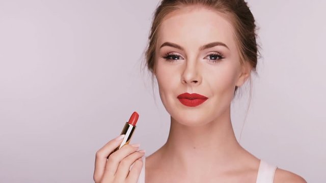 close-up of pretty girl applying red lipstick